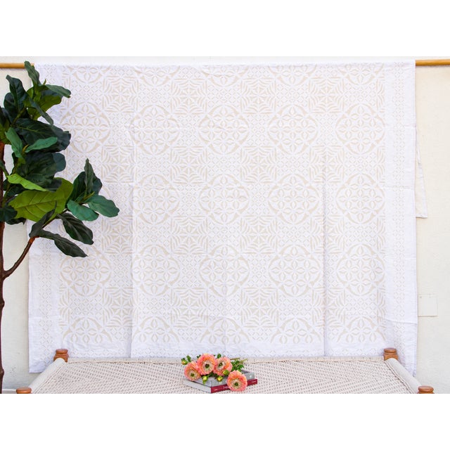 A lightweight cotton coverlet from Western India, beautifully adorned with intricate handcrafted appliqué cutwork. The...