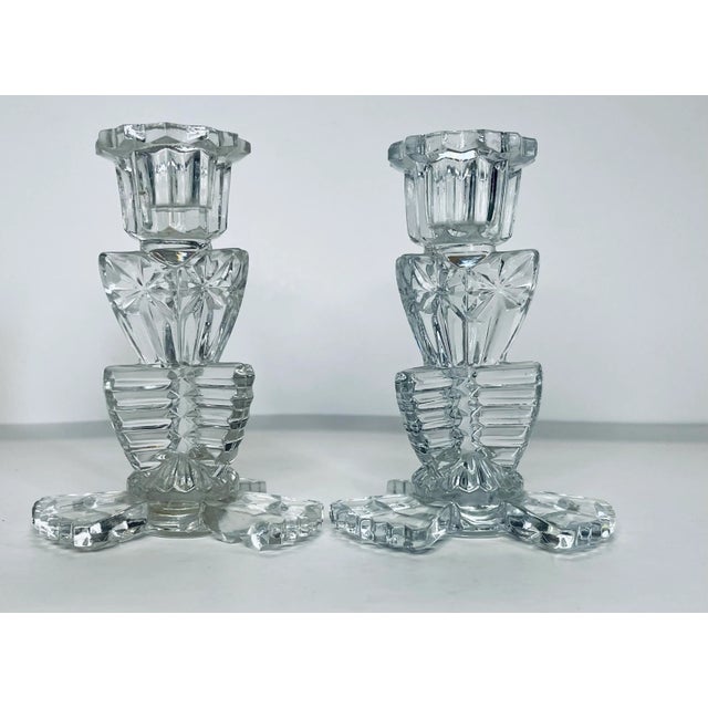 A pair of early 20th century faceted glass candlesticks in an geometric pattern.