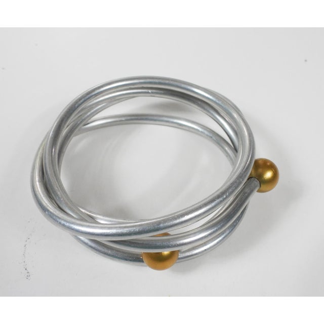 Late 20th century aluminum wire wrap bracelet with gold color balls. Some small spots of oxidation, inside width 2.5".
