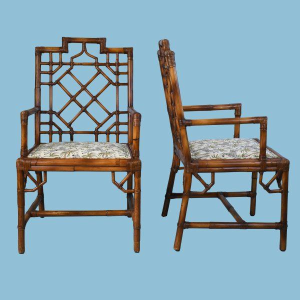 Pair of British Colonial-style armchairs with intricate fretwork rattan frames and woven seats. The open fretwork design...