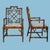Pair of British Colonial-style armchairs with intricate fretwork rattan frames and woven seats. The open fretwork design...