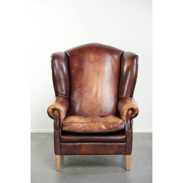 This comfortable English-style cowhide wing armchair features a beautiful warm color scheme and a characterful appearance....
