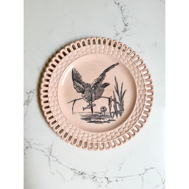 Two Longwy plates in the "Marly" pattern. Each plate features a detailed central transferware scene of a bird framed by an...