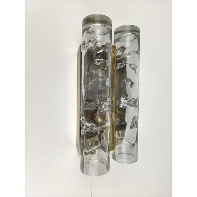 Elegant pair of wall lights by Doria Leuchten, Germany, featuring textured clear ice glass shades mounted on metal...