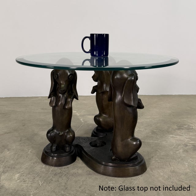 (Please note: glass top not included). A whimsical yet sculptural bronze table base featuring three stylized dachshunds...