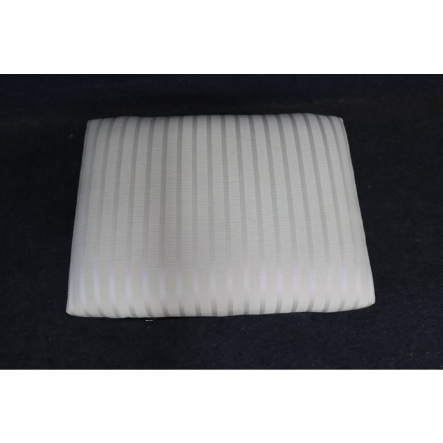 Mid Century style low stool with chrome x-base stretcher and cream upholstery.