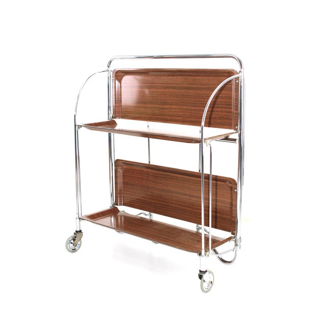 Bar cart by Bremshey / Solingen, so-called dinette, foldable on both sides, brown plastic tops, chrome frame This piece...