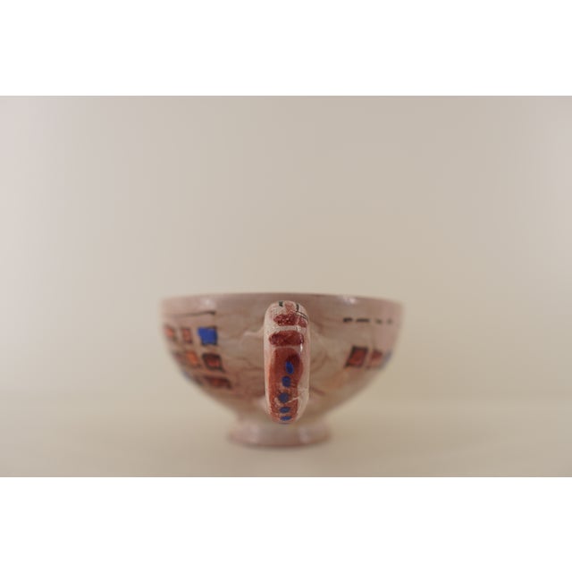 This vintage studio pottery bowl presents a beautifully handcrafted twin-handled form, distinguished by its expressive...