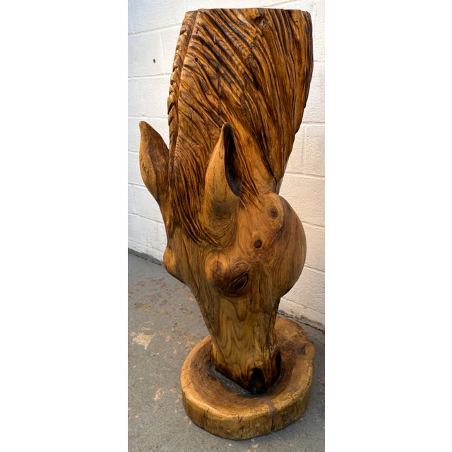 Carved from a single piece of Red Oak hardwood, showing natural grain patterns, knots, and warm amber tones. The mane...