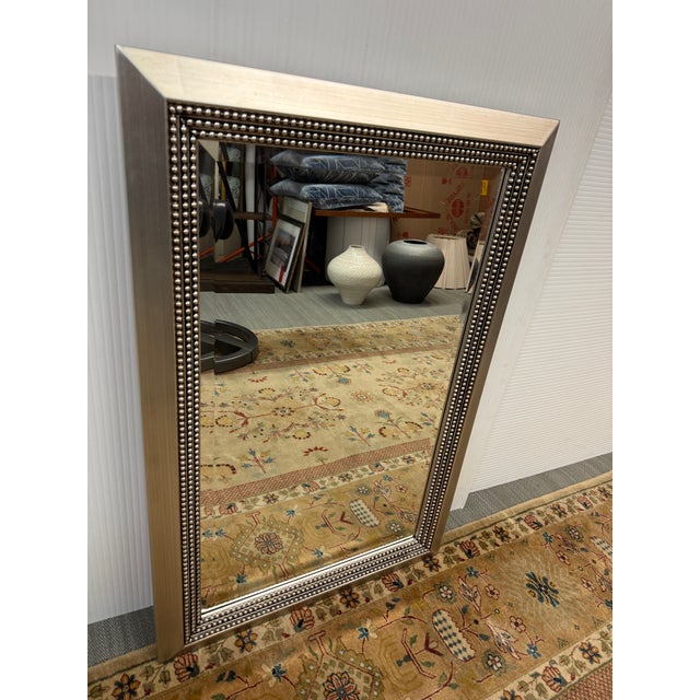 Design Plus Gallery presents a Silver Triple Beaded Wall Mirror from Uttermost. The mirror is encased in a wooden frame...