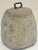 A hand-hewn English tethering stone of granite with an iron loop handle from the 19th century, used as a farm weight or...