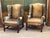 A fine pair of 19th C. English wing back chairs upholstered in mottled brown leather with brass tack trim along the wings,...