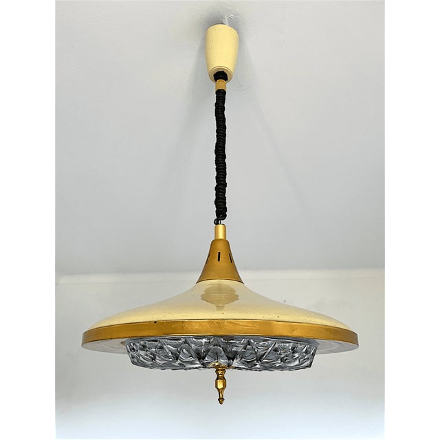 Elegant vintage pull-down pendant light combining warm gold-toned brass and cream lacquered metal shade with a large,...