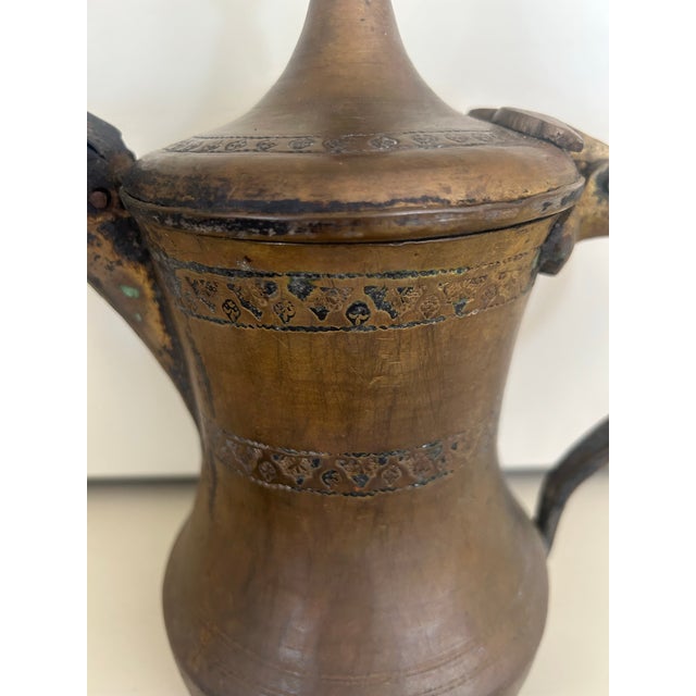 This item is a traditional Middle Eastern Dallah coffee pot, crafted from brass, used for brewing and serving Arabic...