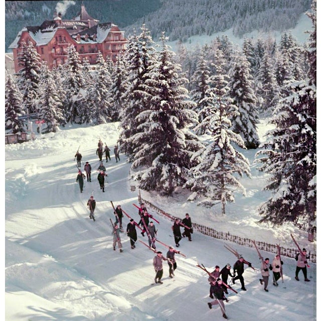 Setting Out by Toni Frissell A group of skiers walk through the street on their way to the ski runs, Klosters,...