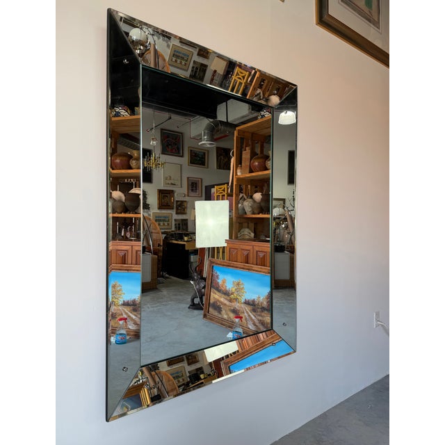 Stunning large-scale 1960’s Hollywood Regency style wall mirror featuring elegant beveled glass panels and a bold,...