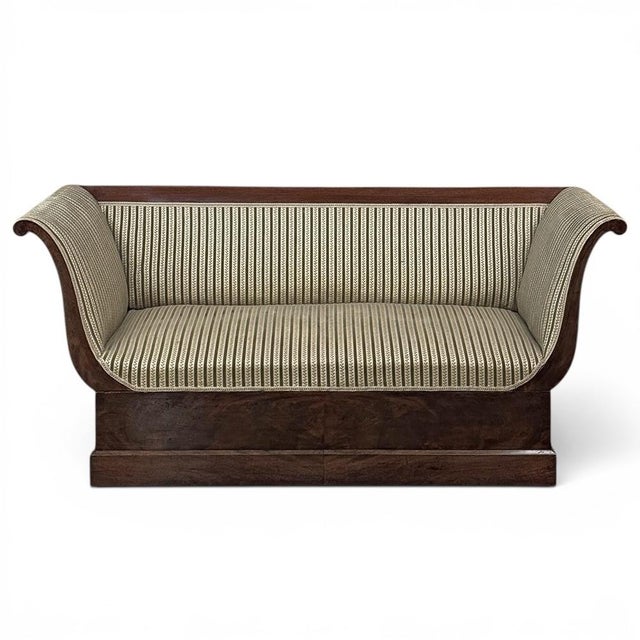 Graceful and sculptural, this early 19th century French sofa reflects the refined elegance of the Charles X period. Rich...