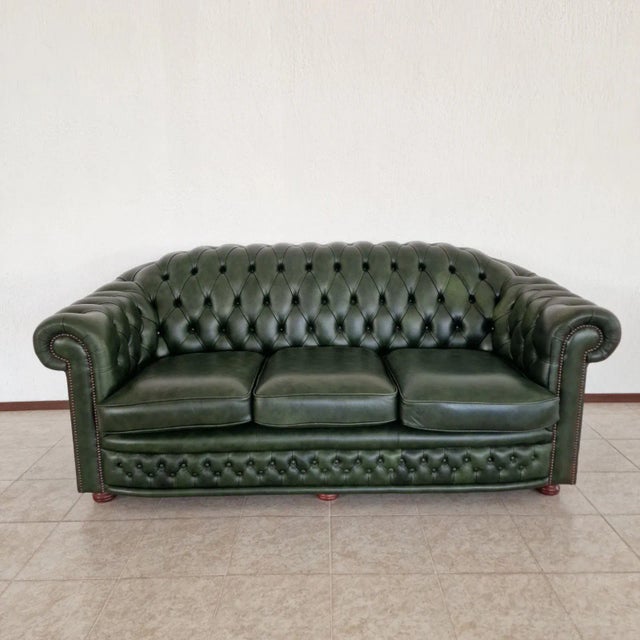 A sophisticated living room set in the classic Chesterfield style, including a three-seater sofa and two armchairs. This...