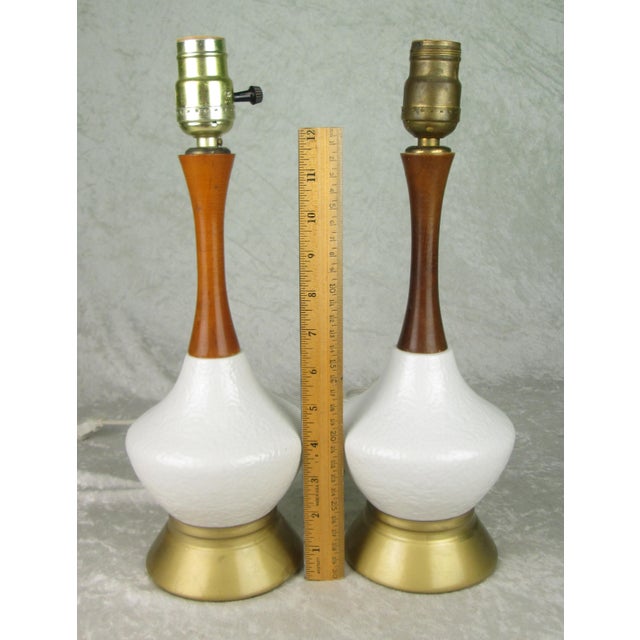 2 vintage mid century modern pottery and wood genie bottle table lamps. The lamps are white pottery with a wood neck that...