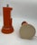 A pair of table lamps with a 1970s space-age design, featuring a cylindrical structure in orange lacquered metal with...