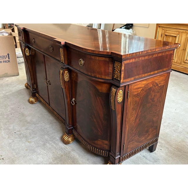 A stunning and substantial signed Maitland-Smith sideboard crafted in richly figured mahogany with elegant Regency and...