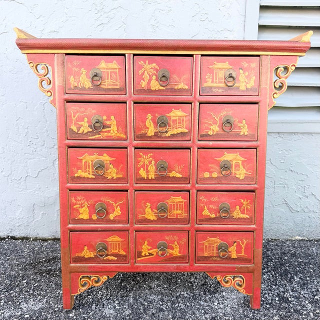 Bring bold Eastern elegance to your space with this vintage Chinese hand-painted red apothecary dresser. The richly...