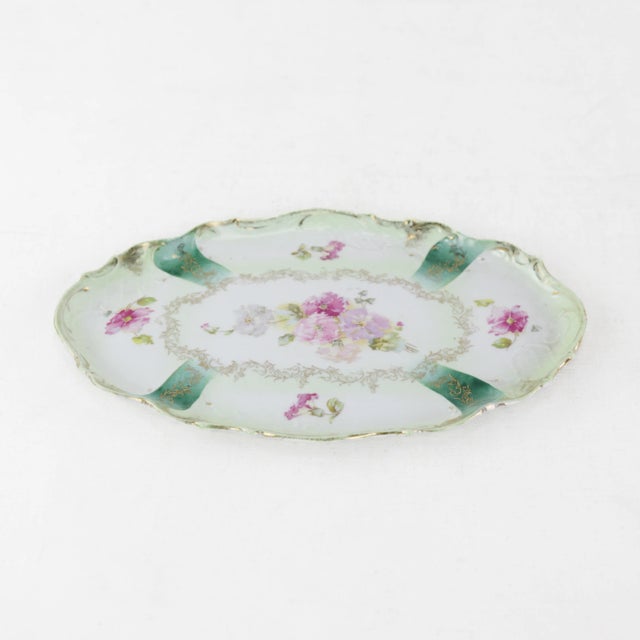 This elegant antique vanity tray showcases a stunning hand-painted design with vibrant pink florals and intricate gold...