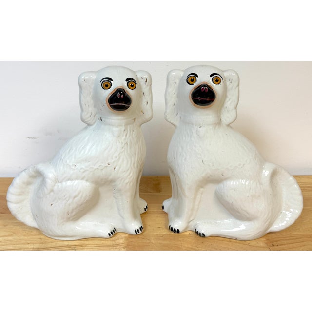 Large Pair of Victorian Staffordshire Spaniel Dogs with Amber Glass Eyes, England, Circa 1860 This impressive pair of...
