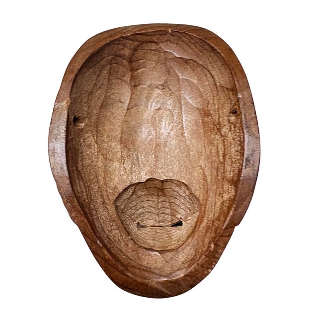 This hand-carved wooden mask is a Japanese Noh mask, that is representative of a character like Okame or Otafuku, which...
