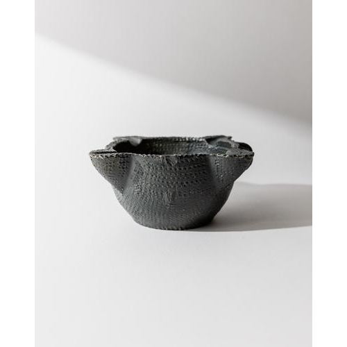 This vintage ceramic ashtray from the 1960s features a striking black hand-carved textured surface in an organic...