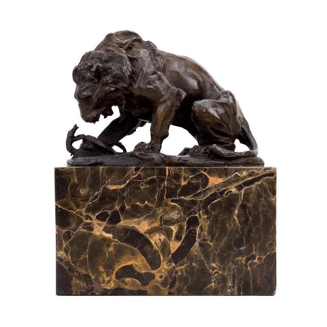 Art Deco style brown patinated bronze animal sculpture representing a lion and serpent. This bronze sculpture is an animal...