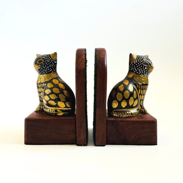 A pair of vintage brass cat bookends. Cats are made of brass attached to wood bases with arched wood backs. Gold brass...