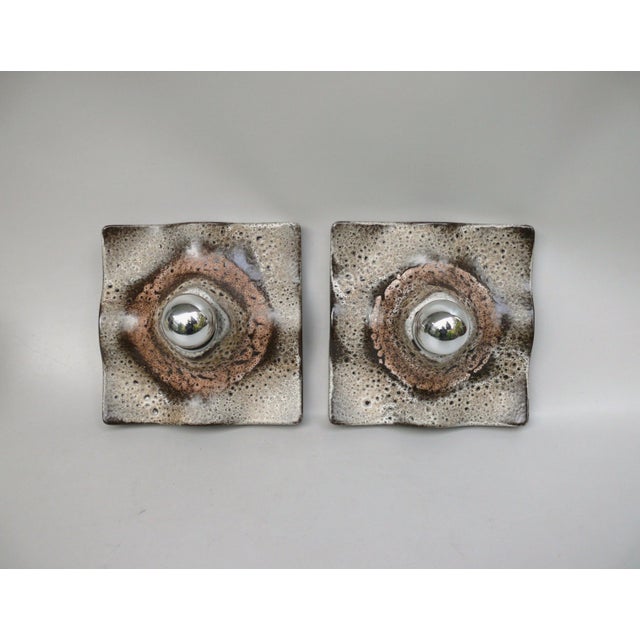 A pair of ceramic wall lights, manufactured by Martin Müller & Co. GmbH, a lighting fixture manufacturer in Neheim-Hüsten,...
