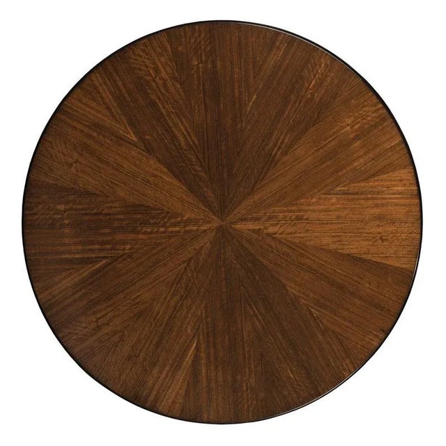 A transitionally styled side table with a round top veneered in exotic Mozambique veneer. The top is placed over four...