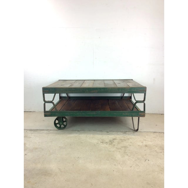 This mid century industrial cart coffee table features painted steel frame, newly refinished wood decking, and custom...