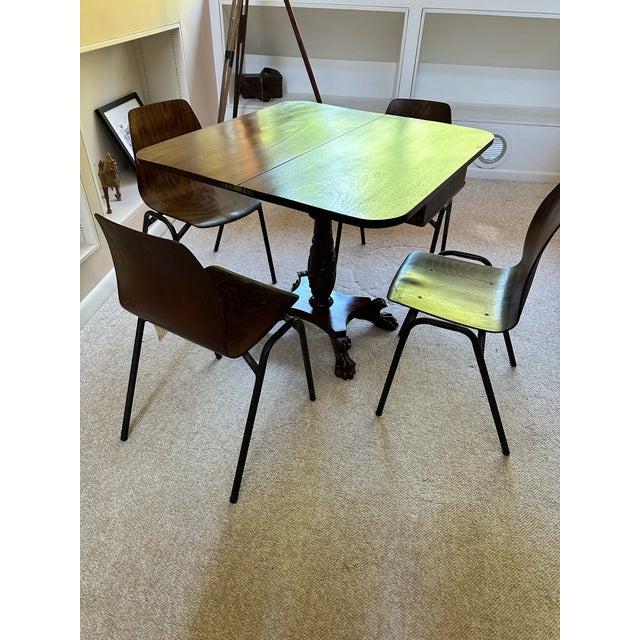 A beautifully proportioned mahogany fold-over tea and game table featuring an intricately carved pedestal base and four...