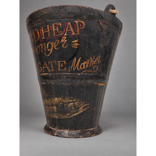 A vintage English wooden bucket with later painted fishmonger’s decoration, 20th century. The tapered, stave-built body...