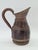 A unique, handcrafted wooden jug shaped like a small barrel, made using traditional cooperage techniques. The piece has a...