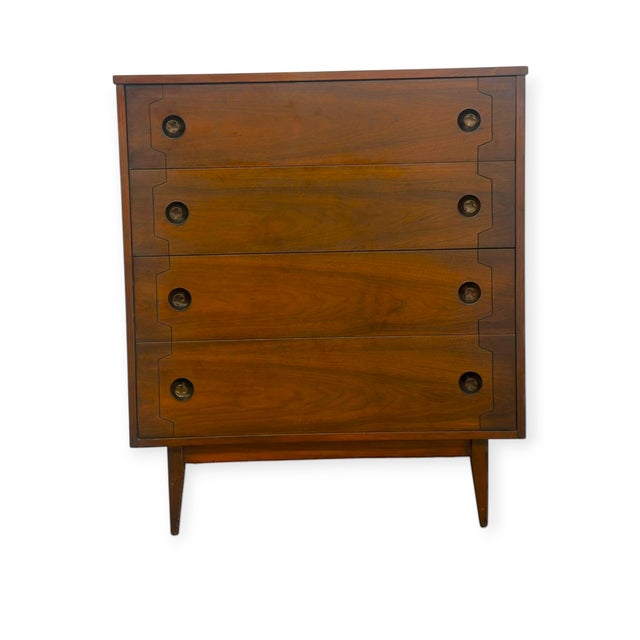 This mid-century modern tallboy chest features a rich wood grain finish across four spacious stacked drawers with clean...