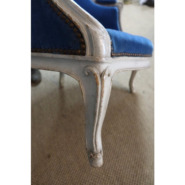 Large and comfortable Louis XV armchair in painted wood upholstered in blue velvet. Early 19th century. The fabric shows...