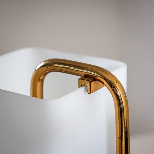 An elegant wall lamp featuring rectangular opaline glass shades and brass fittings. The wall mount bears the original...