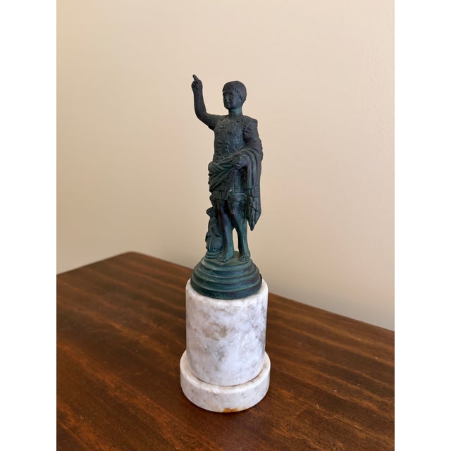 A classic Grand Tour style figure rendered in brass with a verdigris-toned finish, mounted on a substantial marble base....