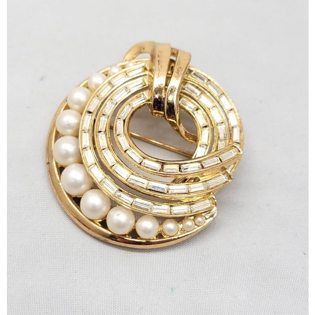 This is part of Chairish’s Costume Jewelry assortment. Late 1950s or early 1960s goldtone circular clear baguette...
