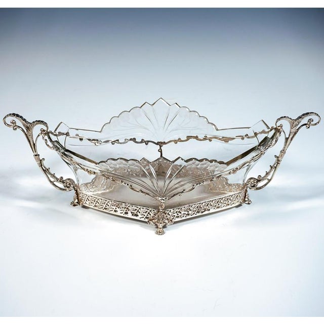 A whimsical jardinière in delicate silverwork with a diamond-shaped base, standing on four lion’s paws, a mounting in the...