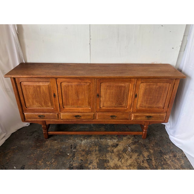 Solid oak sideboard with (4) locking cabinet doors with original hardware. There are (4) drawers below doors with carved...
