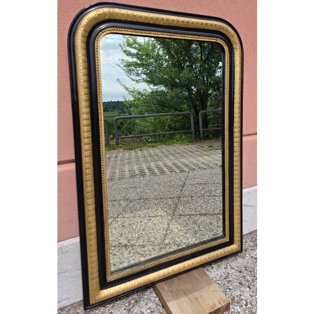 An elegant French-made mirror dating back to the late 19th century. The frame features a refined combination of gold leaf...