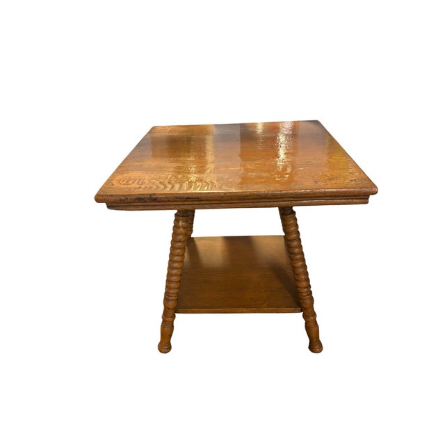 Solid oak side table featuring turned barley twist legs and a lower storage shelf. The warm oak finish and traditional...