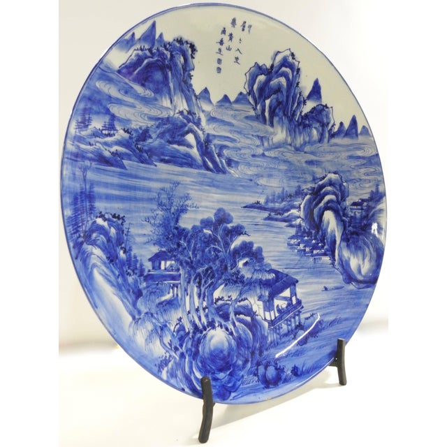 We are offering a massive hand-painted blue and white plate from China. A swirling water scene flows through the mountains...