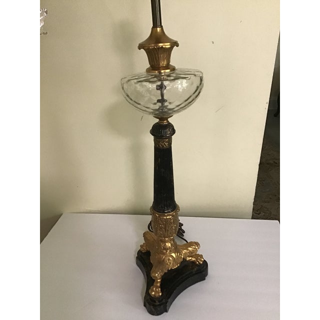 French Empire Neoclassical Table Lamp Beautiful black and gold with clear glass topper On a gold gilt with 3 claw feet On...