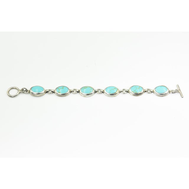 Mexican Sterling Silver and Turquoise Link Bracelet A Mexican sterling silver bracelet featuring oval blue-green turquoise...
